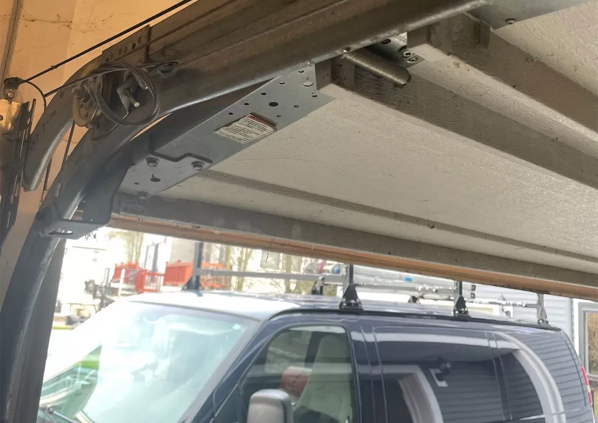 Technician Inspecting Garage Door Springs Professional inspection during Garage Door Maintenance in Needham Heights